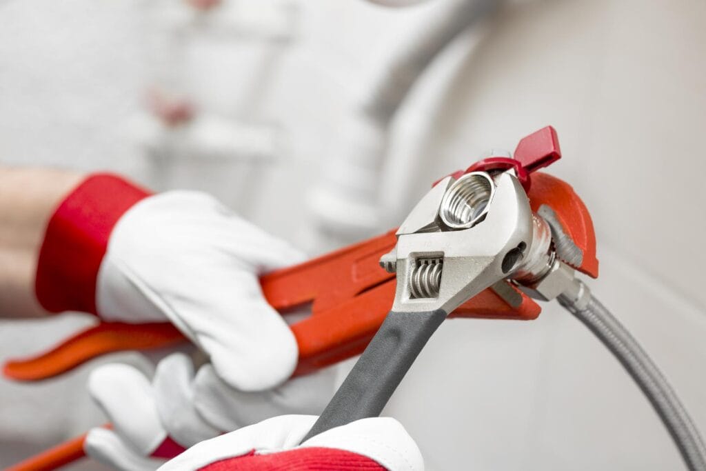 Plumber holding pipe wrenches for an emergency repair in North Port