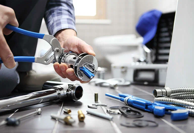 Technician repairing a plumbing fixture with professional tools in North Port