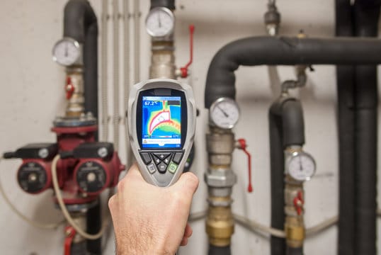 Plumber using a thermal imaging camera to inspect pipes in North Port