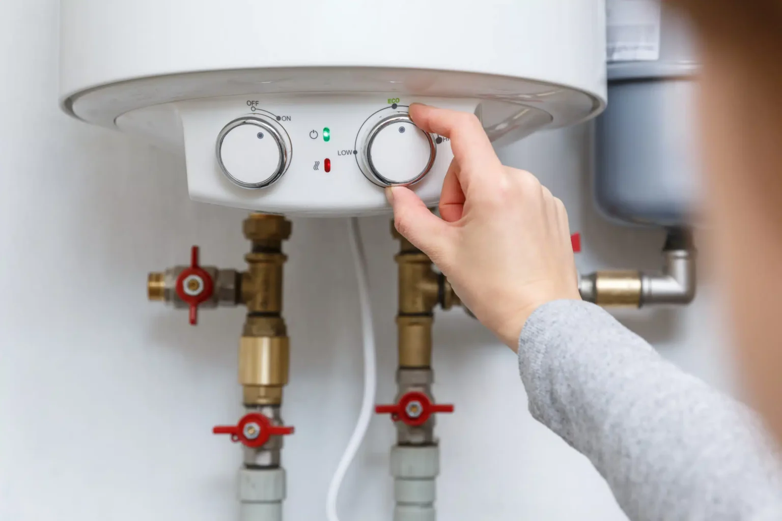 Homeowner adjusting the temperature controls on a water heater in North Port